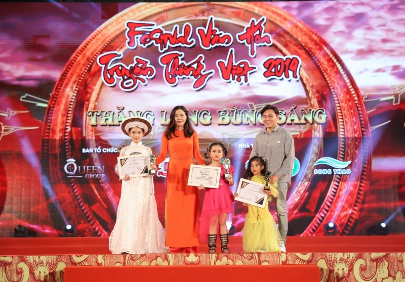 Nhà báo Đông Vũ (phải) cùng đại diện Ban tổ chức trao giải cho các bé và Thiên Long